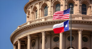 American and Texas state flags flying on the dome of the Texas State Capitol building in Austin